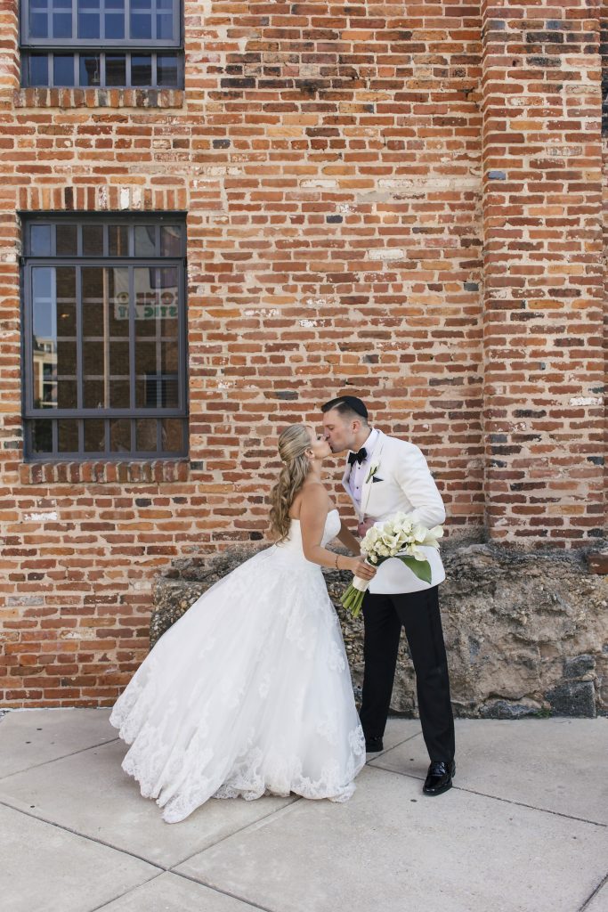 Bride and Groom Kissing Outside of the American Visionary Arts Museum. Howerton+Wooten Events.